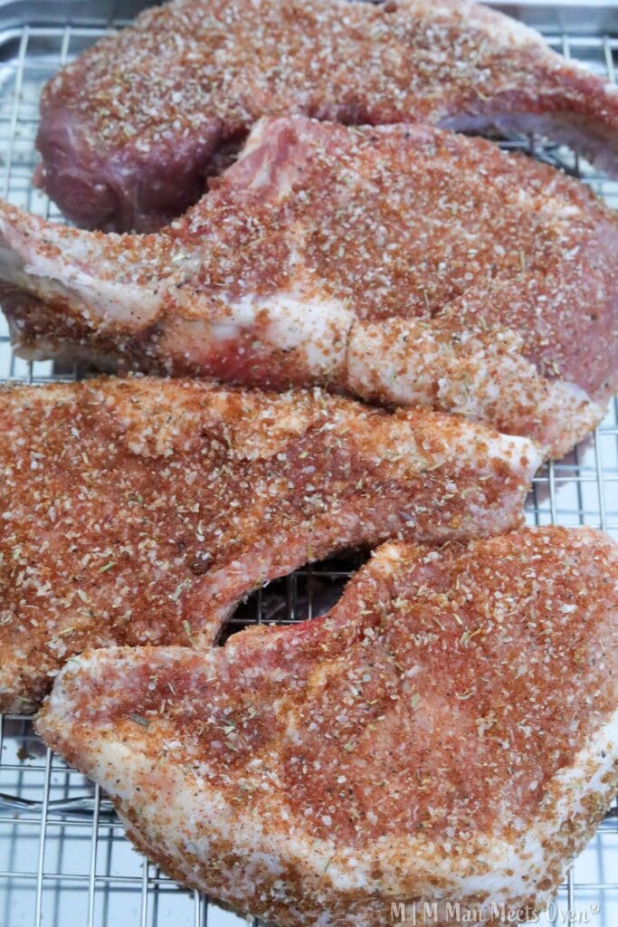 Pork chops in dry brine on a baking rack