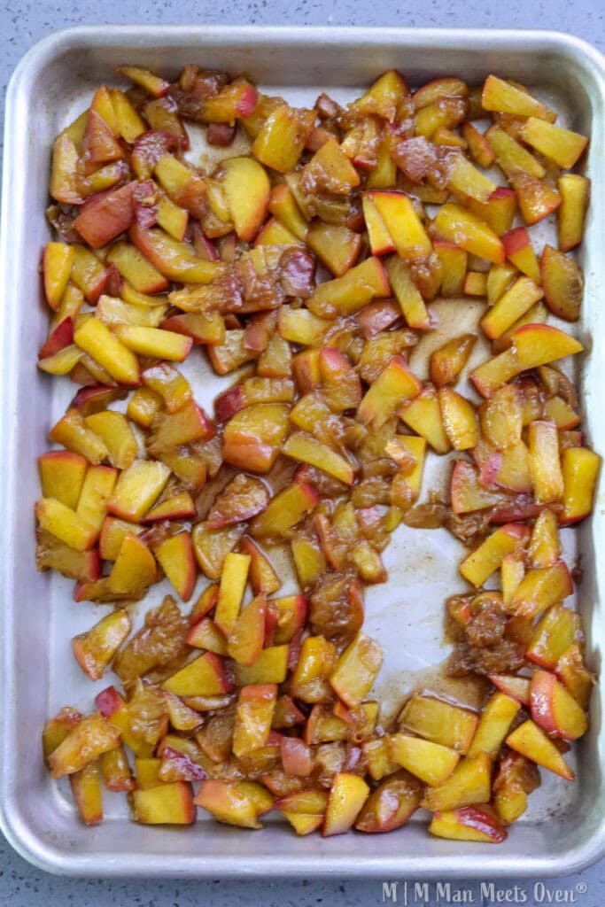 Sliced peaches in a baking tray.