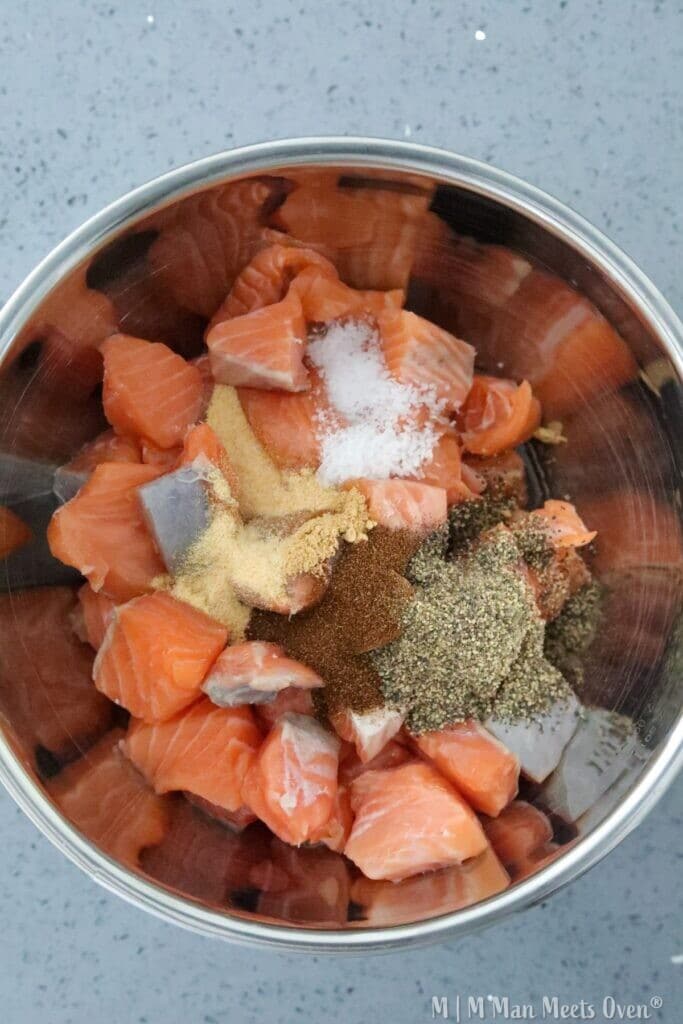 Raw salmon chunks with seasonings added
